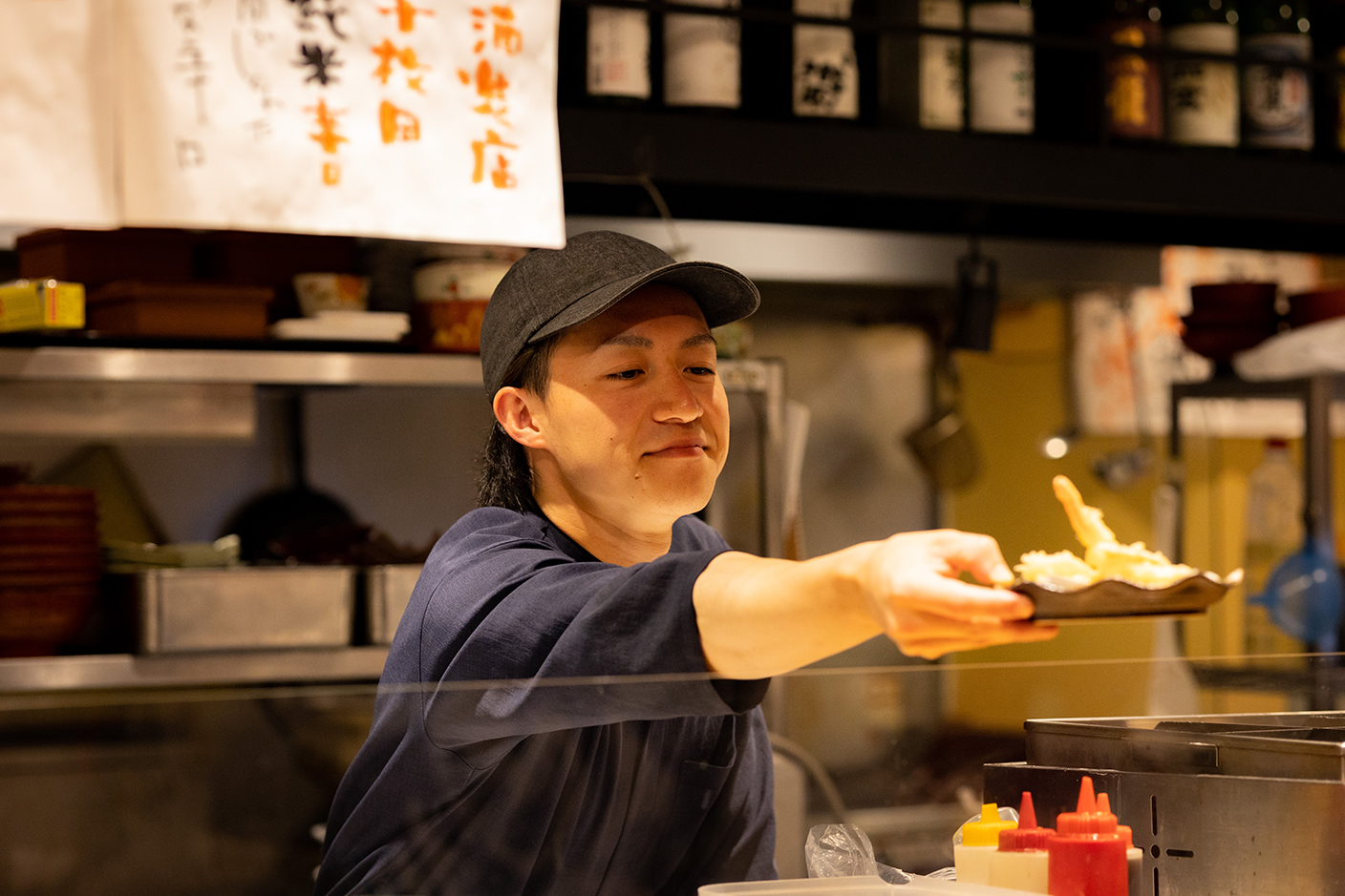 仕事風景 制服を着た店員が料理を提供する画像